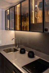 Elegant modern kitchen with illuminated glass cabinets and sleek countertops.
