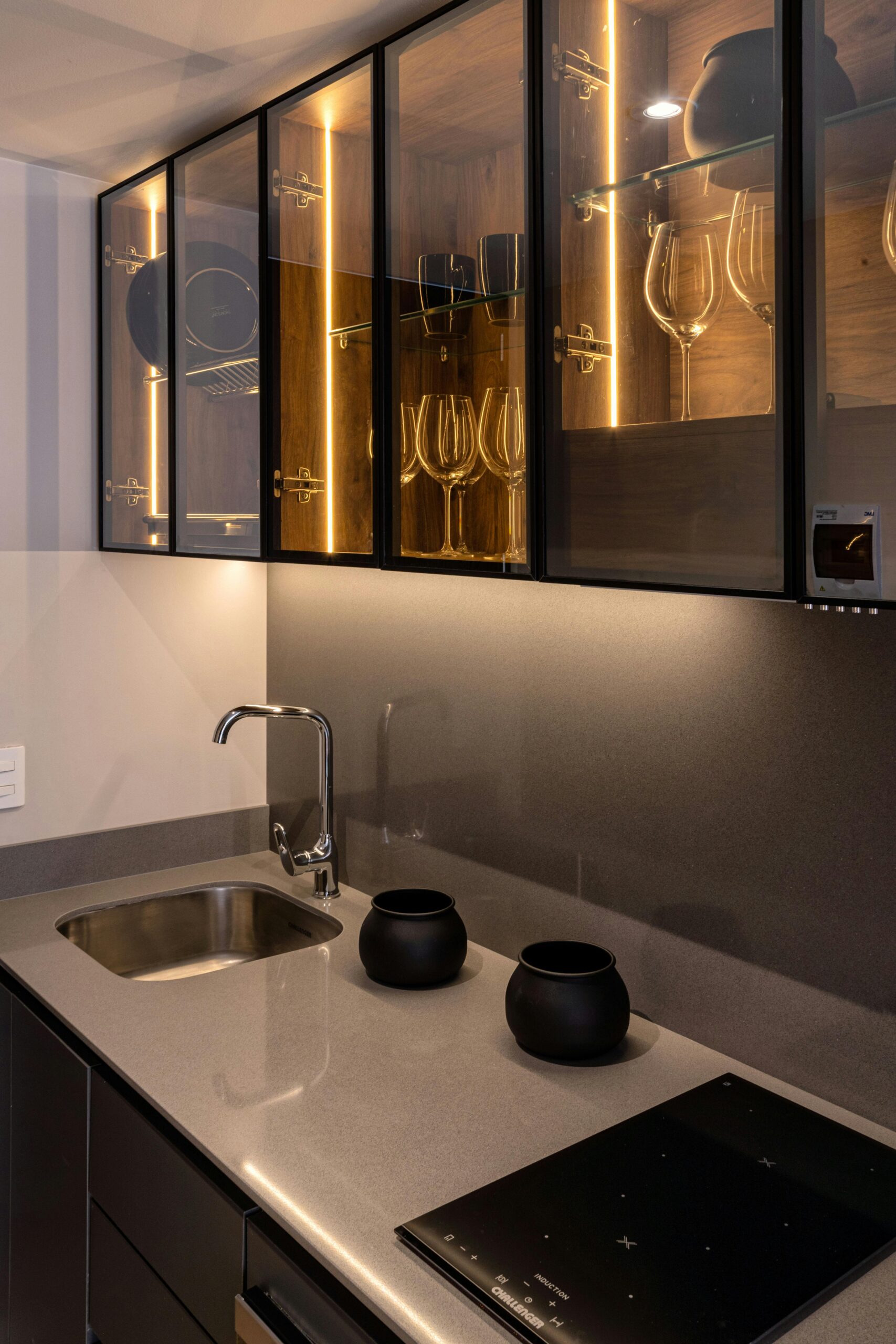 Elegant modern kitchen with illuminated glass cabinets and sleek countertops.